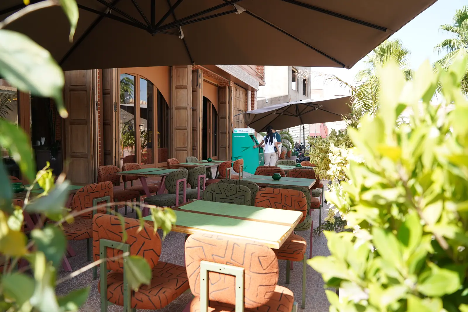 Shaded terrace tables framed by plants and parasols