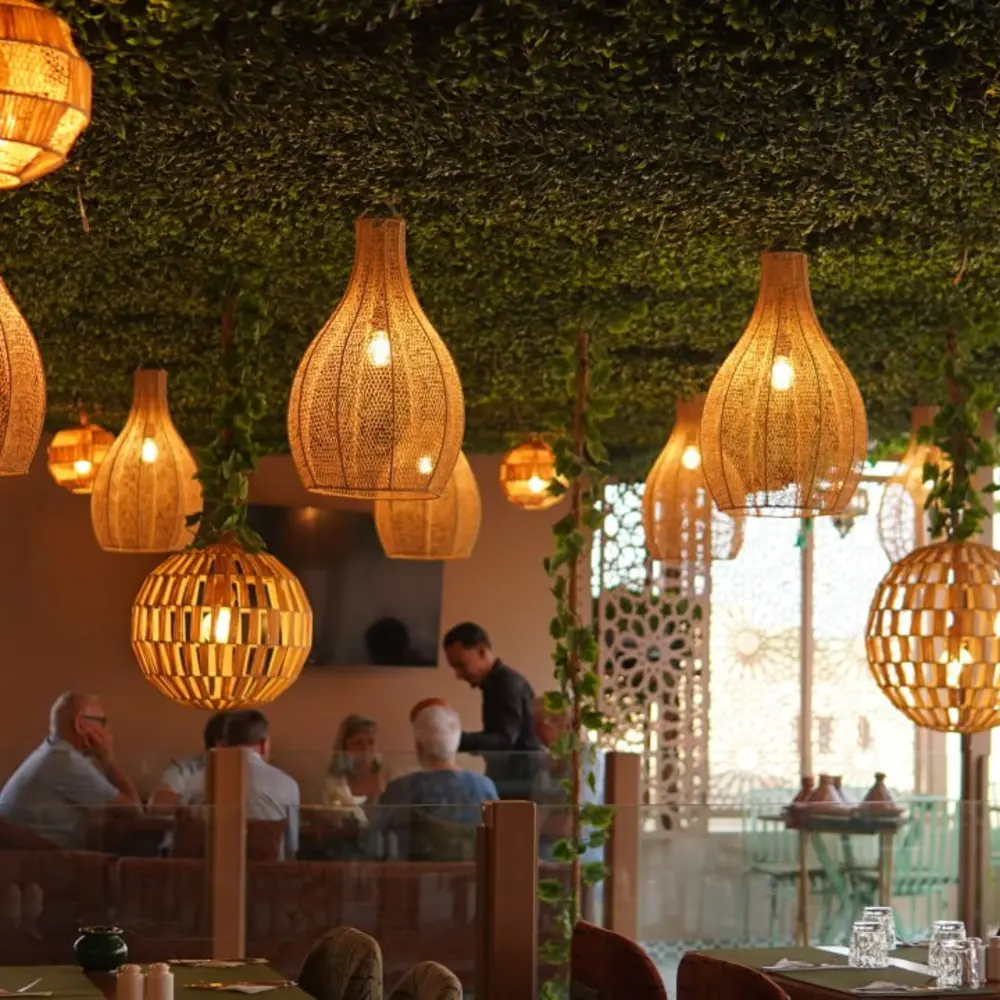 Woven rattan lanterns above guests dining on the terrace