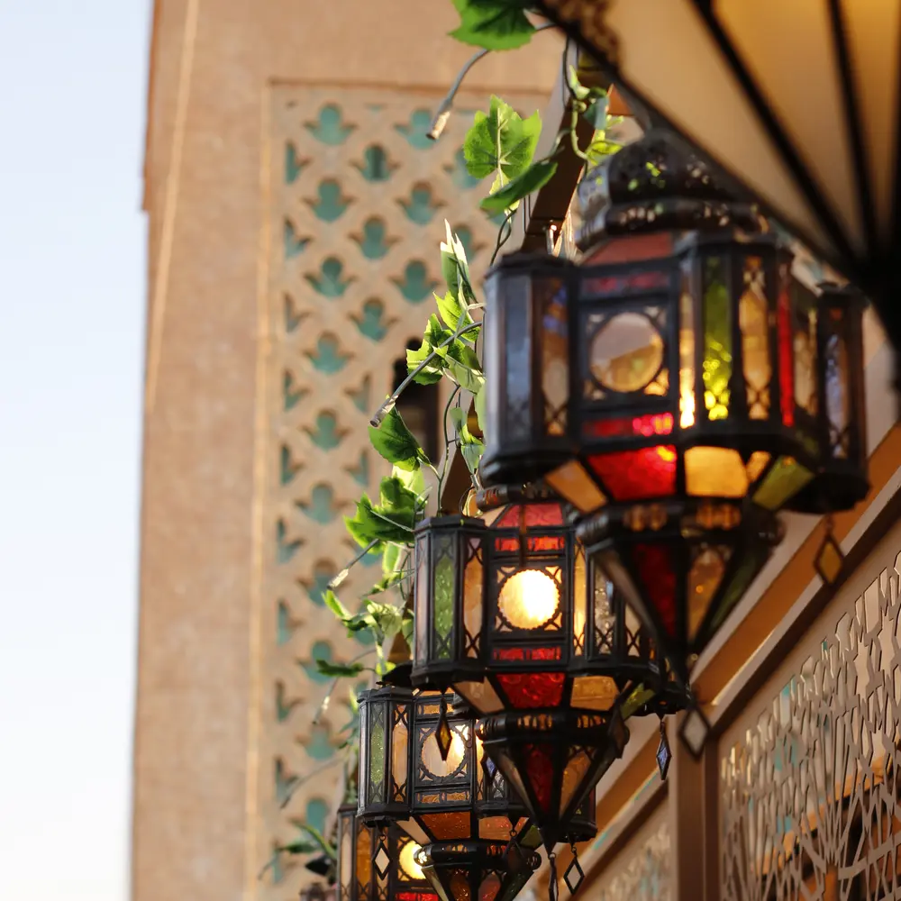 Moroccan brass lanterns hanging beside a carved minaret