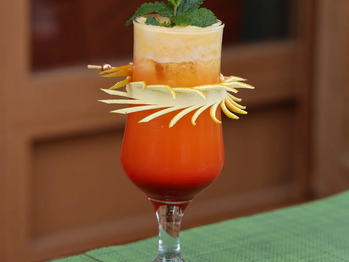 Layered tropical juice with a carved fruit crown