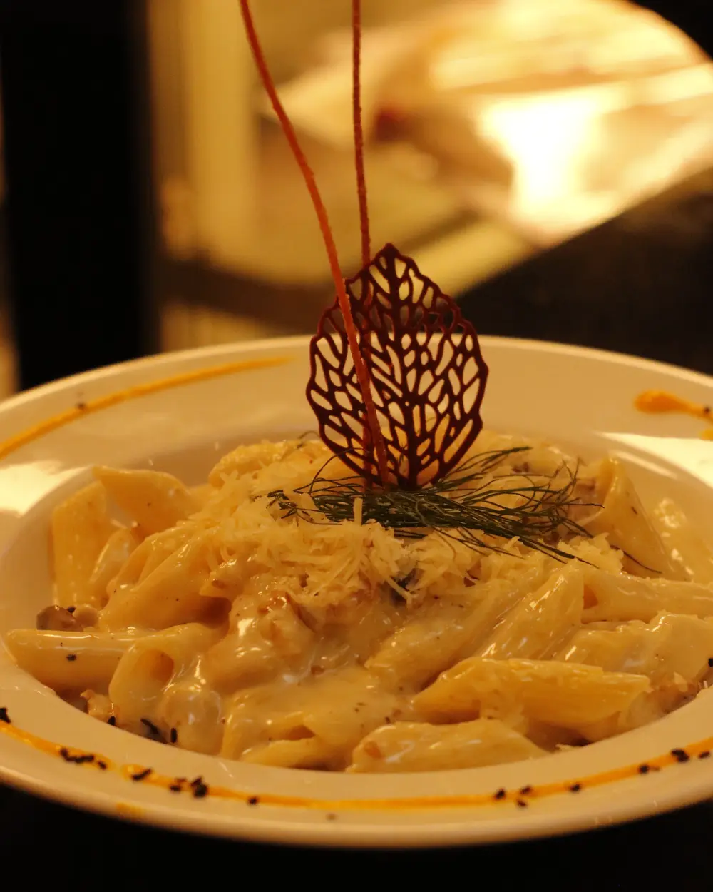 Penne in a creamy sauce with a chocolate leaf garnish