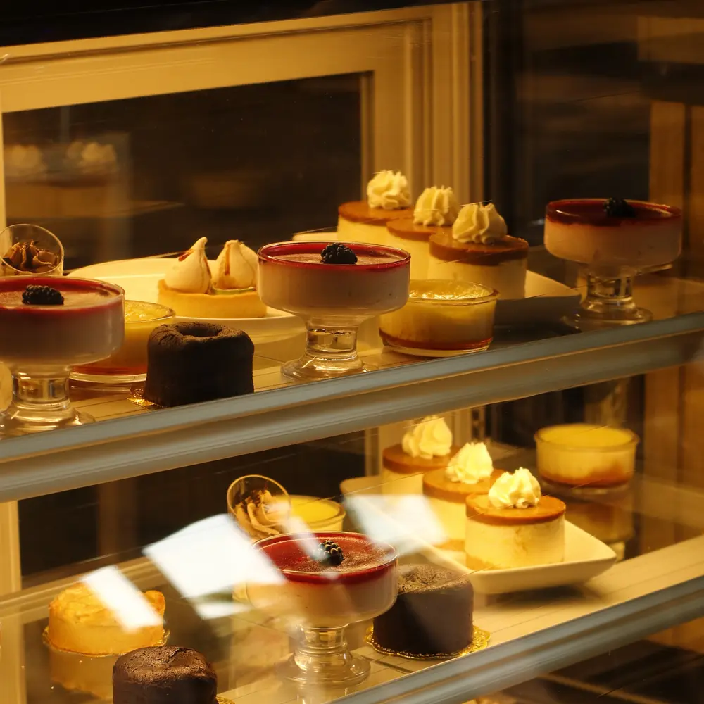 Glass display of cakes, tarts and individual desserts